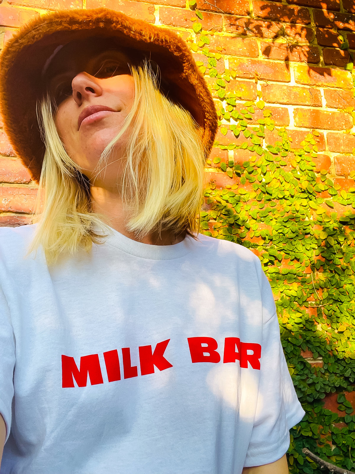 Woman wearing the white MILK BAR Everyday Original Tee outdoors